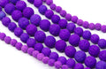 Purple and lava stone bead strands on a white background.
