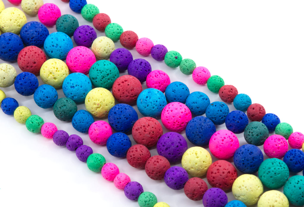 Multiple strands of porous lava stone beads in a rainbow of colors, including blue, pink, purple, green, yellow, and red, arranged diagonally on a white background.