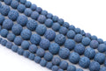 multiple strands of Blue porous lava stone beads arranged in diagonal strands on a white background.