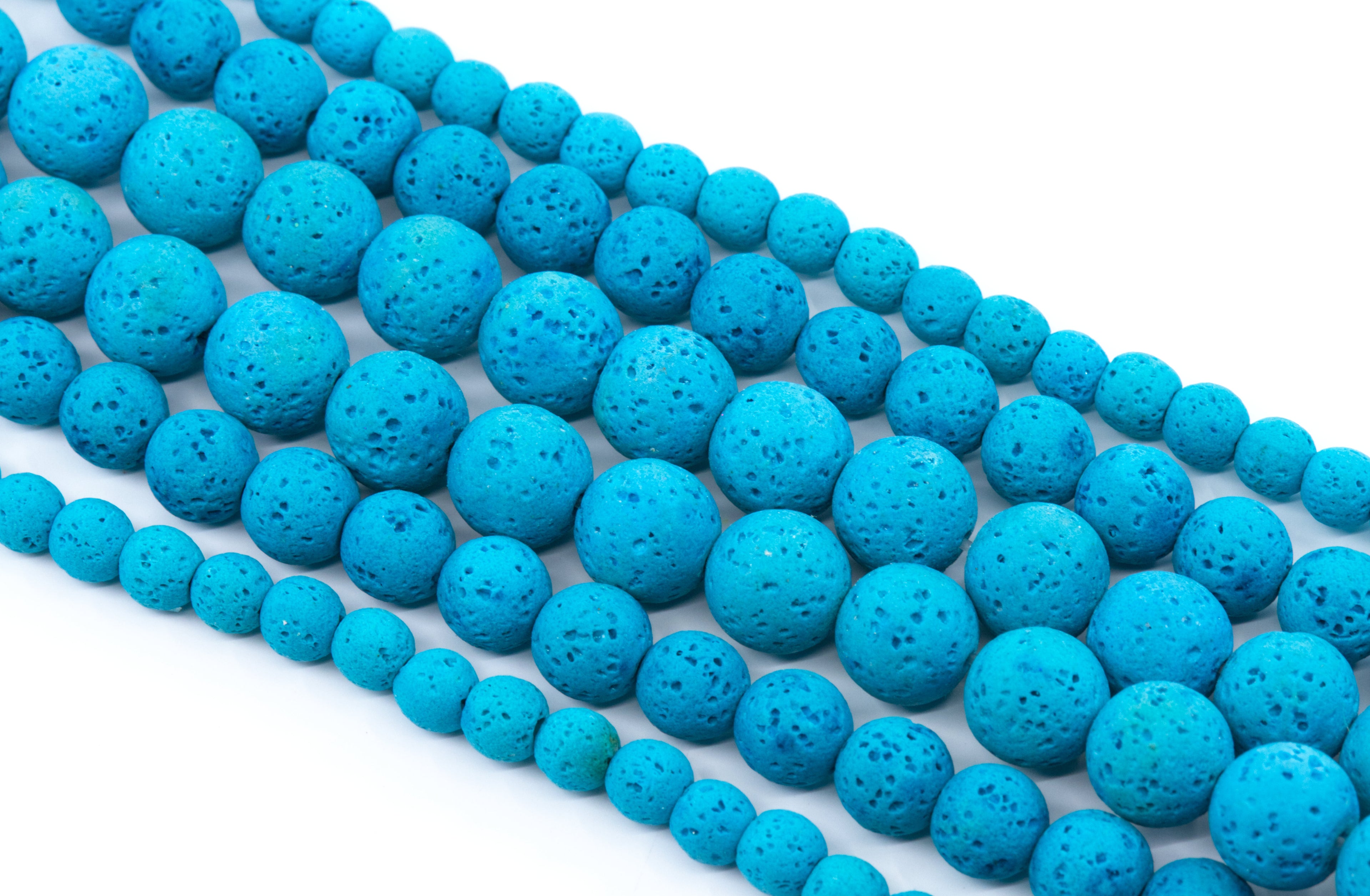 Multiple strands of bright blue porous lava stone beads arranged diagonally on a clean white background.