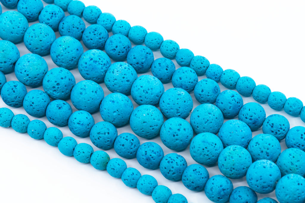 Multiple strands of bright blue porous lava stone beads arranged diagonally on a clean white background.
