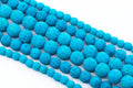 Multiple strands of bright blue porous lava stone beads arranged diagonally on a clean white background.