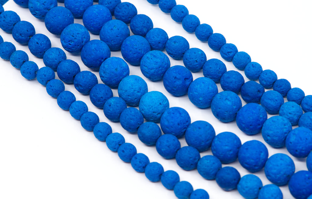 Multiple strands of textured blue lava stone beads arranged diagonally on a clean white background.