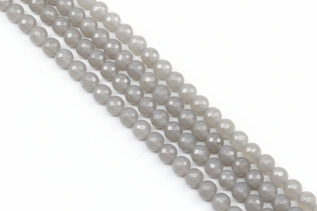 Faceted round agate beads in pale gray  arranged in diagonal rows on a light gray background.