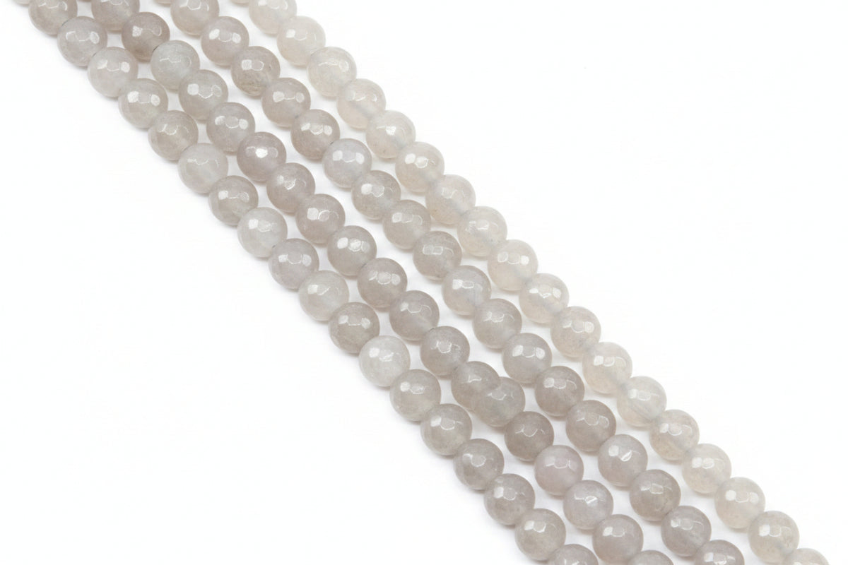Faceted round agate beads in pale gray  arranged in diagonal rows on a light gray background.