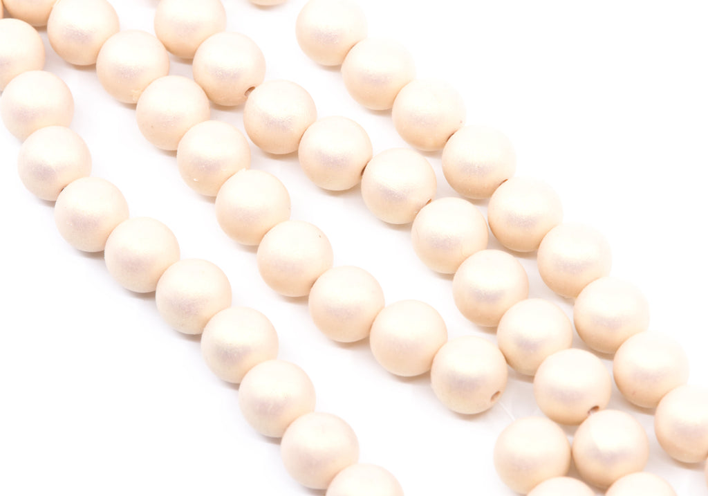 peach colored shimmer acrylic beads arranged in diagonal strands on a white background.