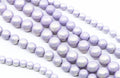 Multiple strands of purple shimmery acrylic beads arranged diagonally on a clean white background.