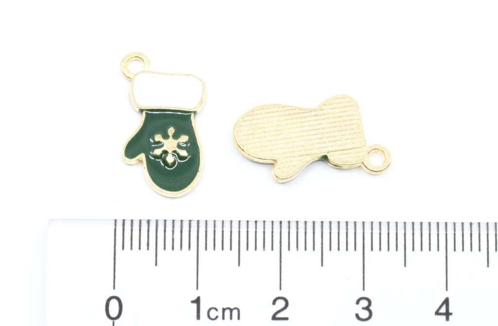 Two small green and white mitten charms next to a cm ruler on a white background.