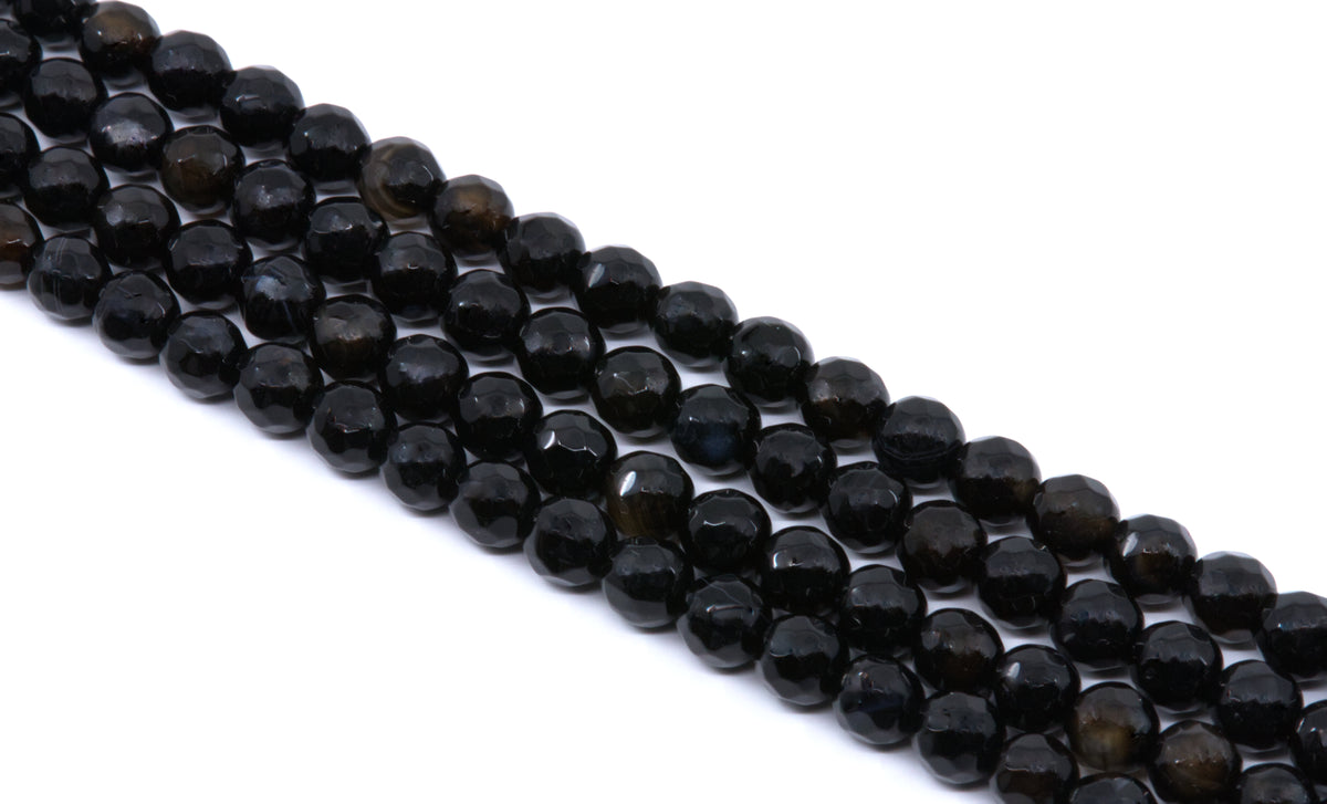 Faceted round agate beads in a  black color, arranged in diagonal rows on a plain white background.