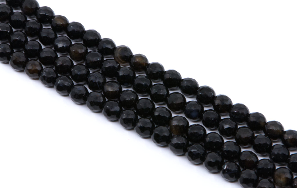 Faceted round agate beads in a  black color, arranged in diagonal rows on a plain white background.