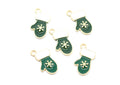 Five green and white Christmas stocking charms with gold-tone metal edges and loops, featuring a white snowflake design on the front, arranged on a plain white background.
