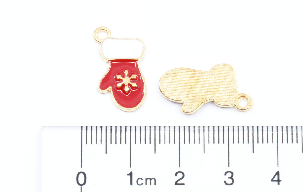 Two enamel mitten gold-tone jewelry charms or pendants shown on a white background with a cm ruler for scale. 