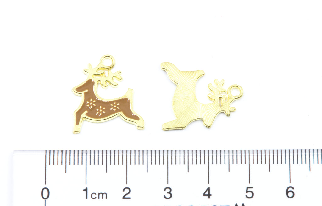 Two small gold Christmas reindeer charms, shown above a cm ruler for scale on a white background.