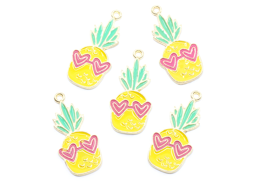 Five pineapple-shaped charms with yellow bodies, mint green leaves, and pink heart-shaped sunglasses, arranged on a plain white background.