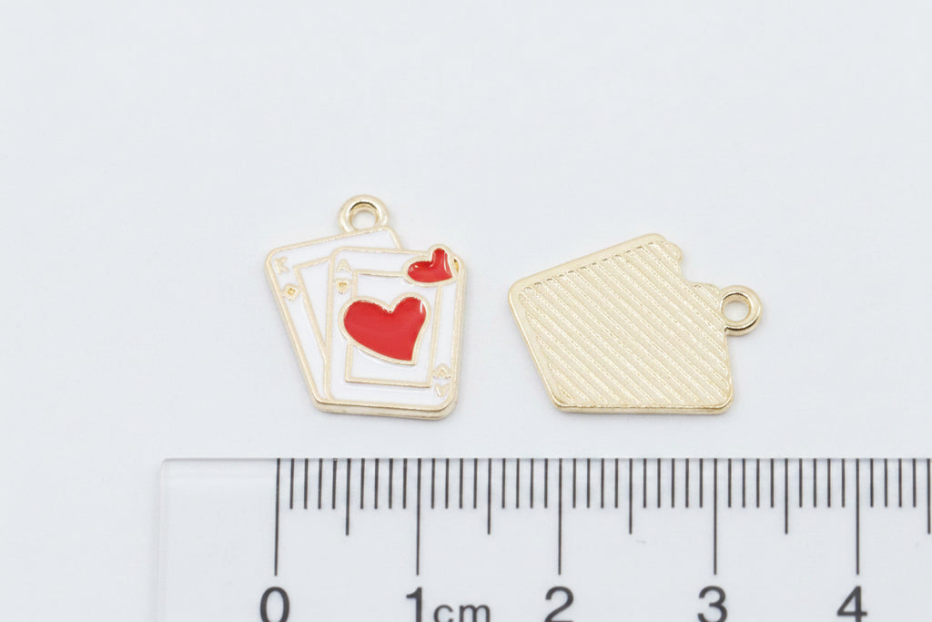 Two small red and white playing card charms shown on a white background with a ruler at the bottom for scale. 