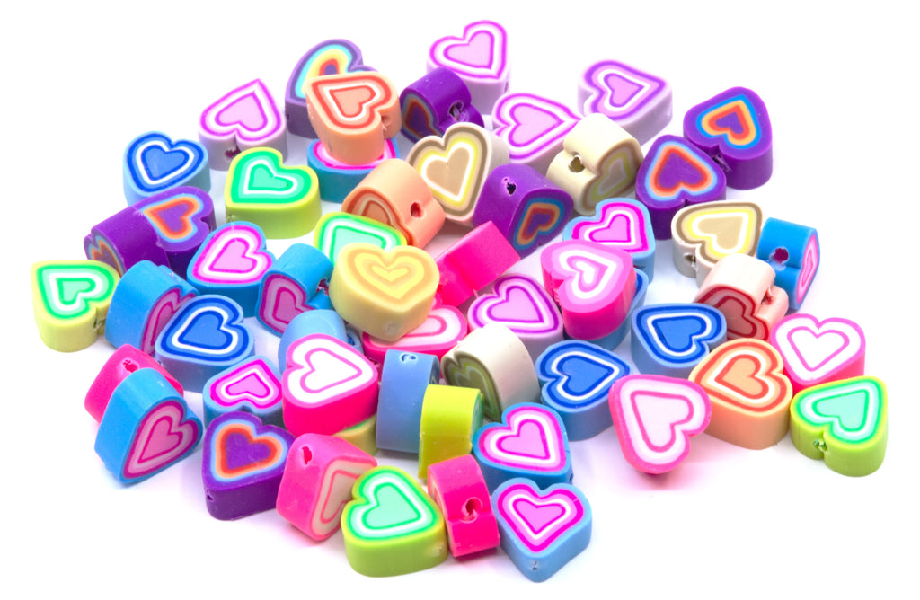 A pile of small heart-shaped polymer clay craft beads in various vibrant colors, including pink, blue, green, purple, orange, and yellow, on a plain white background.