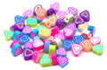 A pile of small heart-shaped polymer clay craft beads in various vibrant colors, including pink, blue, green, purple, orange, and yellow, on a plain white background.