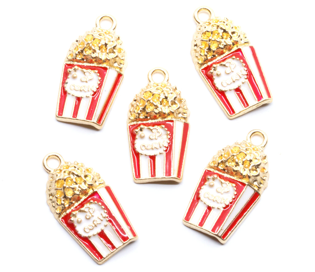 Five popcorn-shaped jewelry charms with red and white striped buckets, gold-tone outlines, and textured gold popcorn tops, arranged on a plain white background.