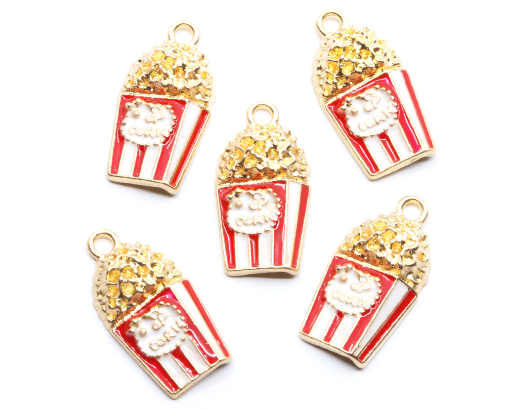 Five popcorn-shaped jewelry charms with red and white striped buckets, gold-tone outlines, and textured gold popcorn tops, arranged on a plain white background.