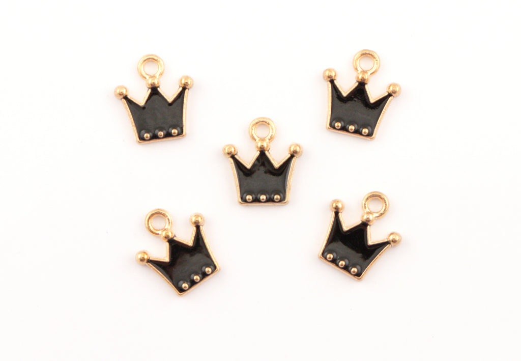 Five small crown-shaped charms with black enamel and gold-tone metal borders, arranged on a plain white background.