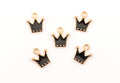 Five small crown-shaped charms with black enamel and gold-tone metal borders, arranged on a plain white background.