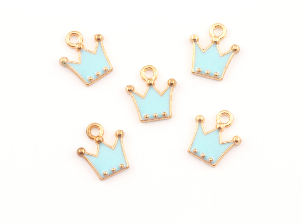 Five small crown-shaped jewelry charms with light blue enamel and gold-tone metal borders, arranged on a plain white background.