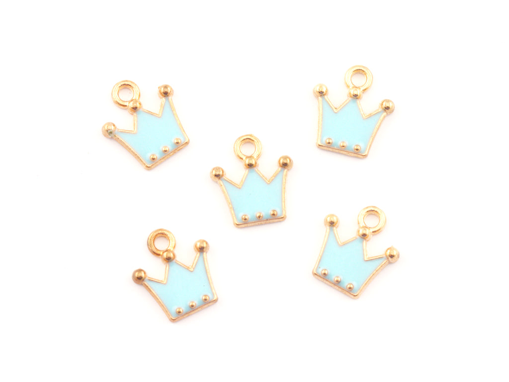 Five small crown-shaped jewelry charms with light blue enamel and gold-tone metal borders, arranged on a plain white background.