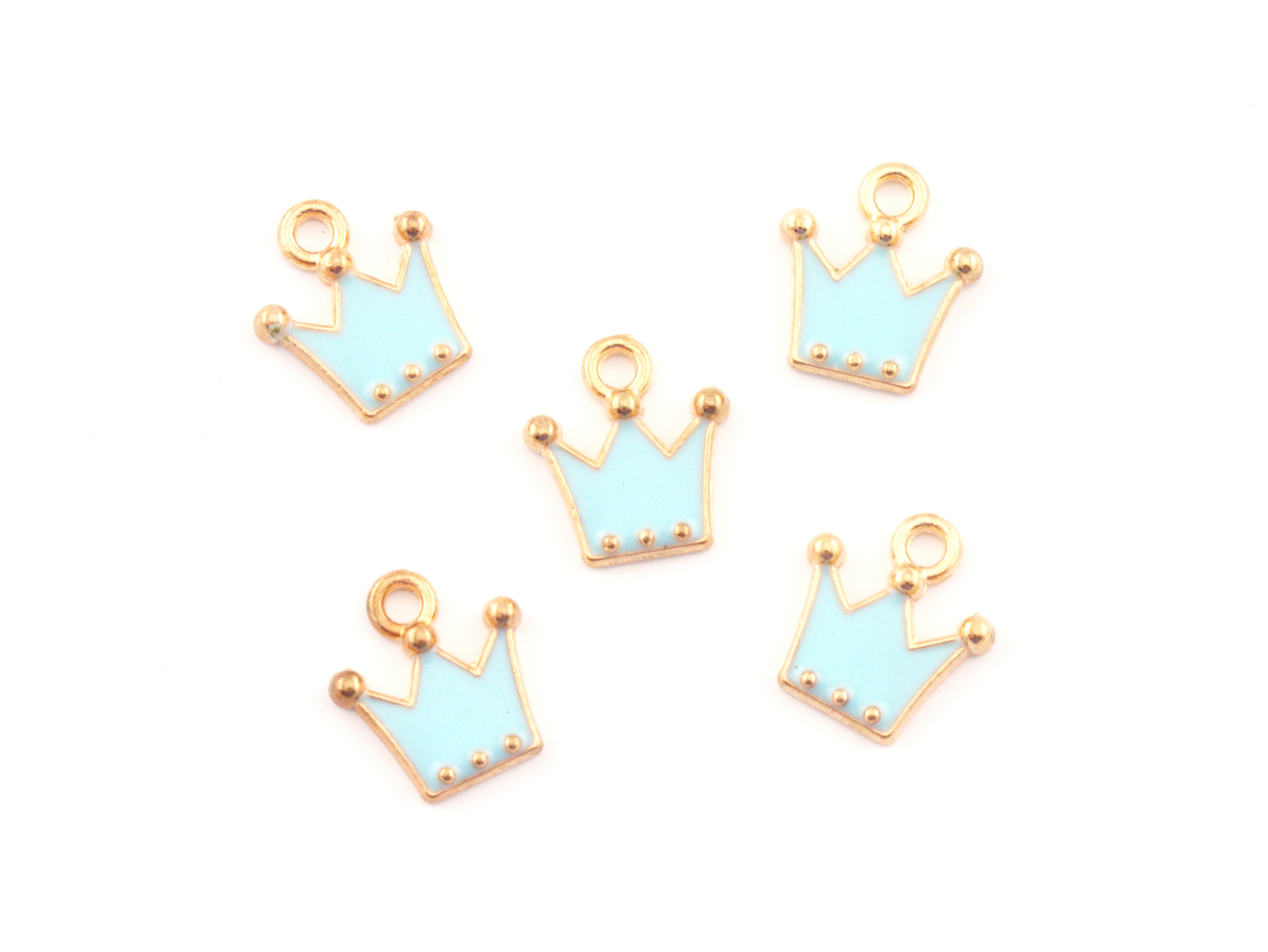 Five small crown-shaped jewelry charms with light blue enamel and gold-tone metal borders, arranged on a plain white background.
