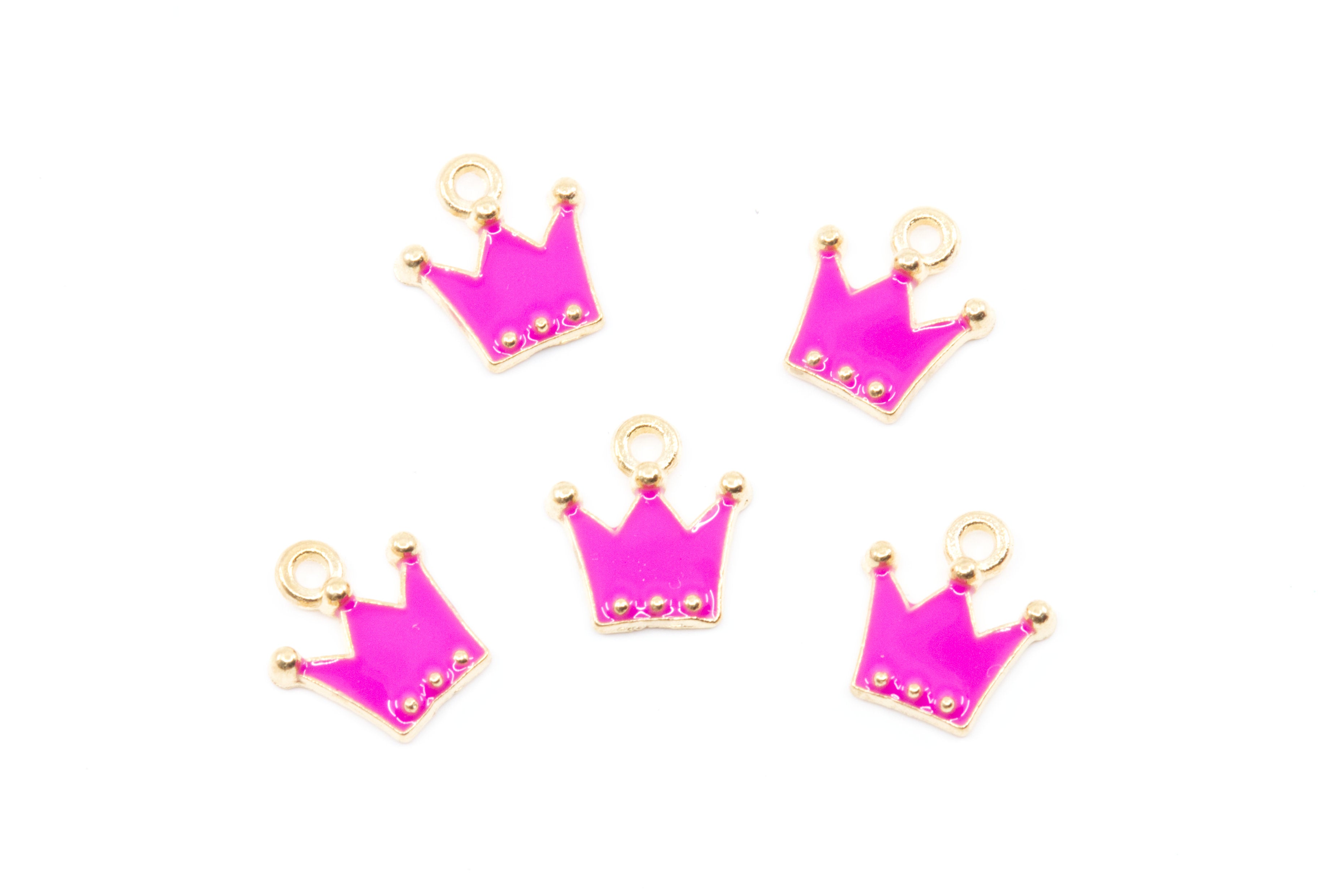 Five small crown-shaped jewelry charms in bright pink enamel with gold-tone metal borders and loops, arranged on a plain white background.