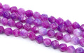 Faceted diamond cut gemstone beads in shades of purple and pink, arranged in diagonal rows on a white background.