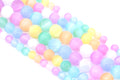 A close-up of multiple strands of pastel rainbow dyed gypsum selenite beads arranged diagonally on a white background.
