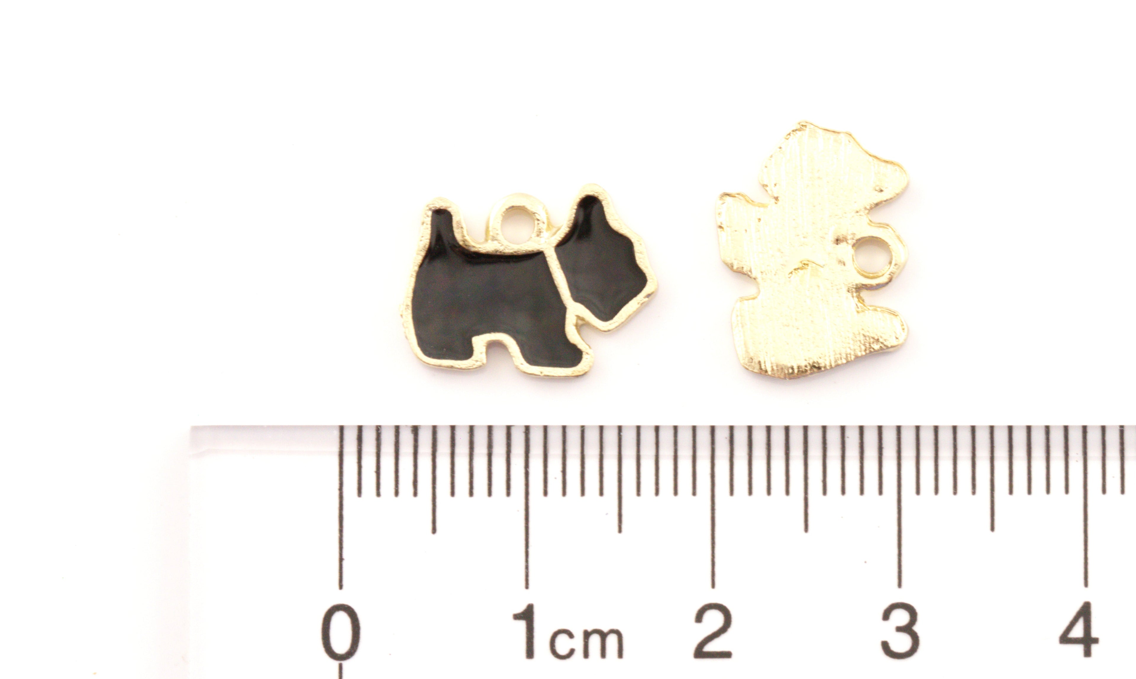 Two small dog-shaped jewelry charms,  displayed above a  cm ruler for scale on a white background.