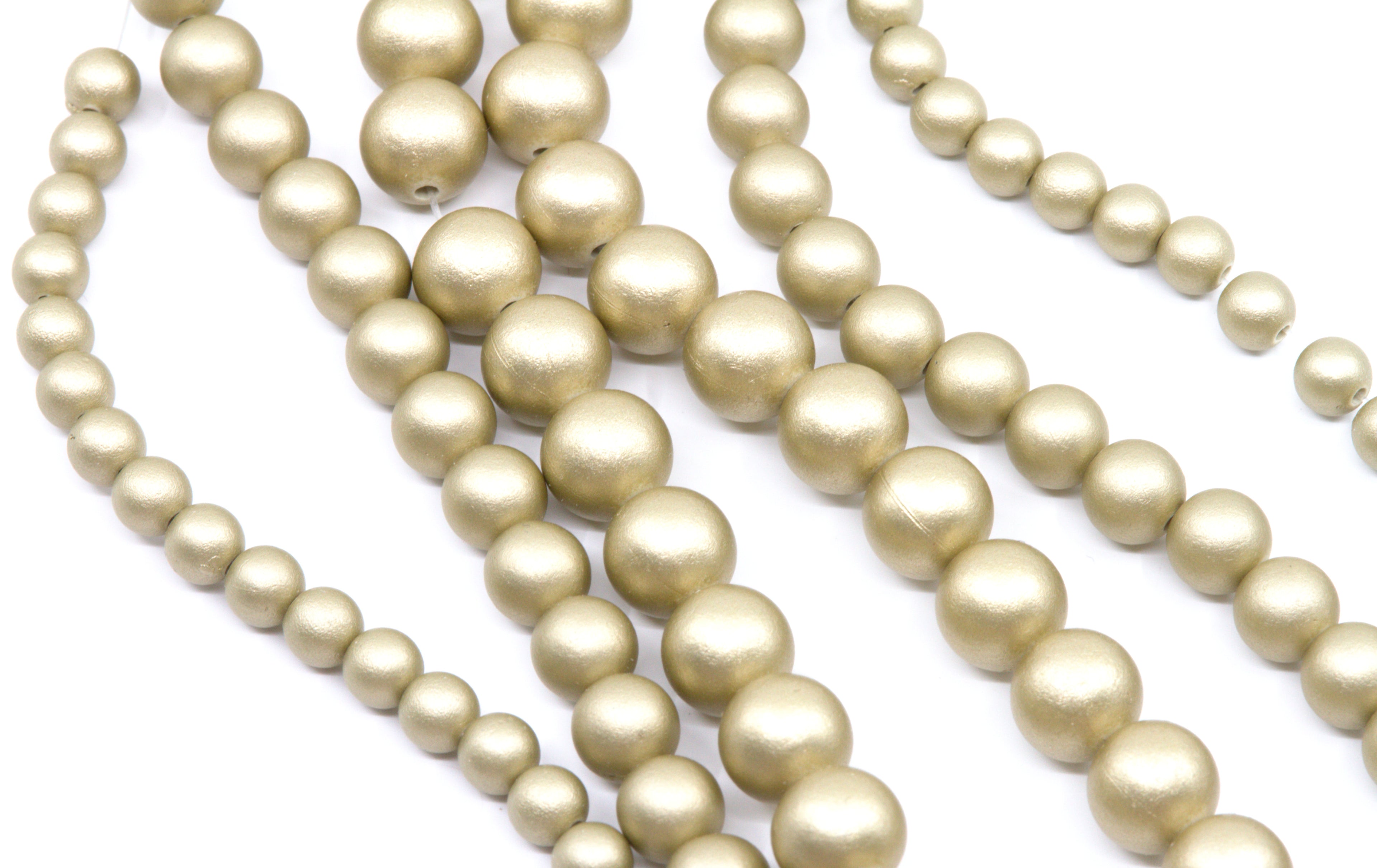 multiple strands of shiny shimmery gold acrylic beads shown on a white background 