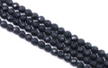 Faceted dark gray agate beads arranged in diagonal rows on a plain white background.