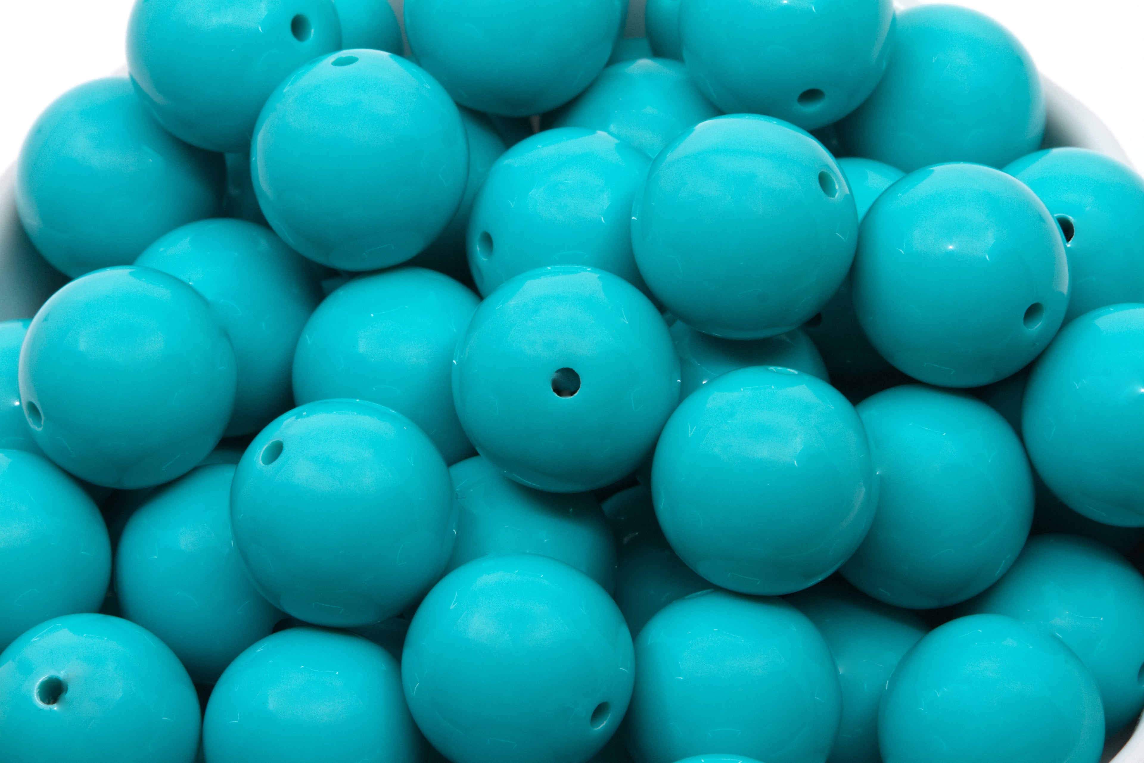 blue beads in a white bowl on a white background