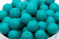 teal blue beads in a white bowl on white background 