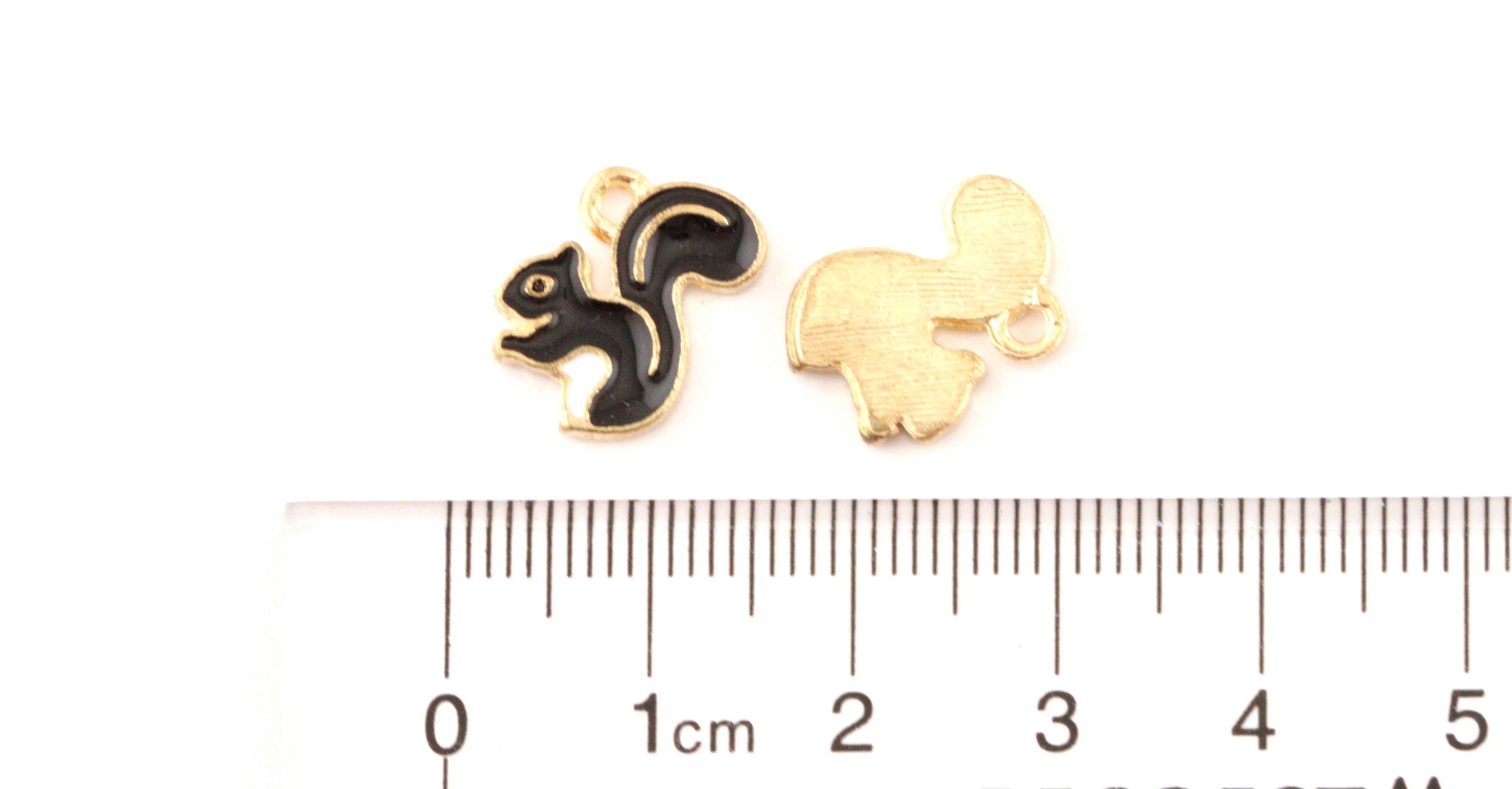 Two small squirrel jewelry charms, shown above a cm ruler on a white background.