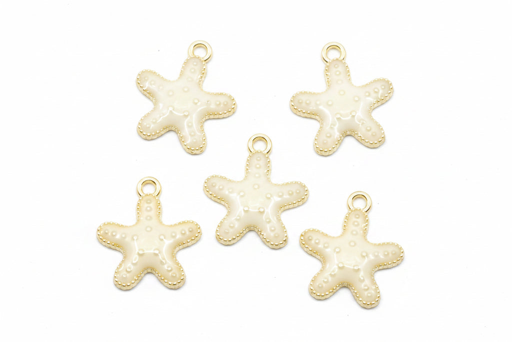 Five small starfish-shaped jewelry charms with cream enamel and gold-tone edges, arranged on a white background.
