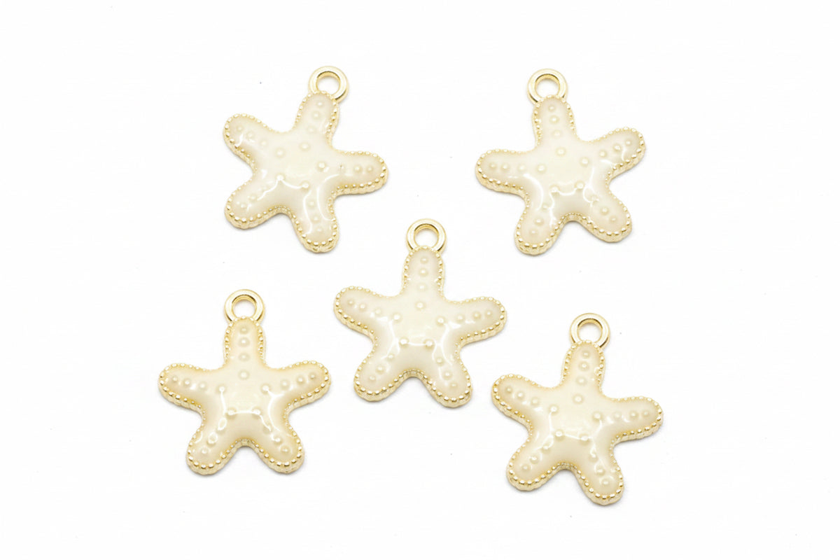 Five small starfish-shaped jewelry charms with cream enamel and gold-tone edges, arranged on a white background.