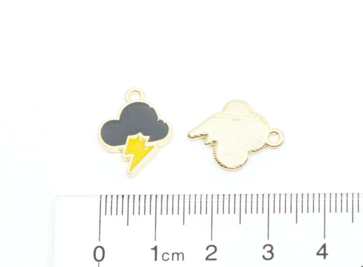 Two small cloud-shaped jewelry charms with a lightning bolt design, shown on a white background above a ruler for scale. 