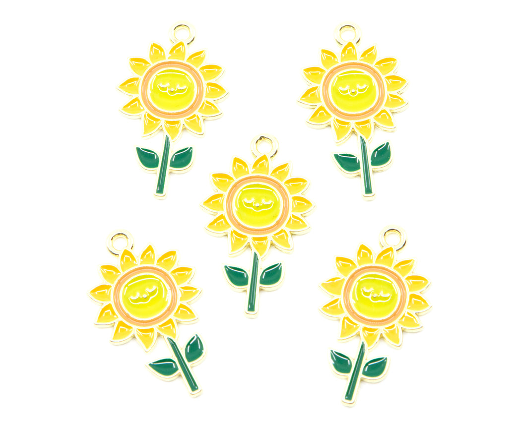 Five yellow sunflower charms with green stems and leaves, each featuring a small gold-tone loop at the top, arranged on a plain white background.