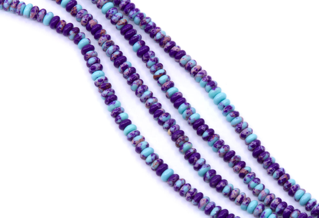 Four strands of rondelle synthetic purple jasper beads displayed diagonally on a white background
