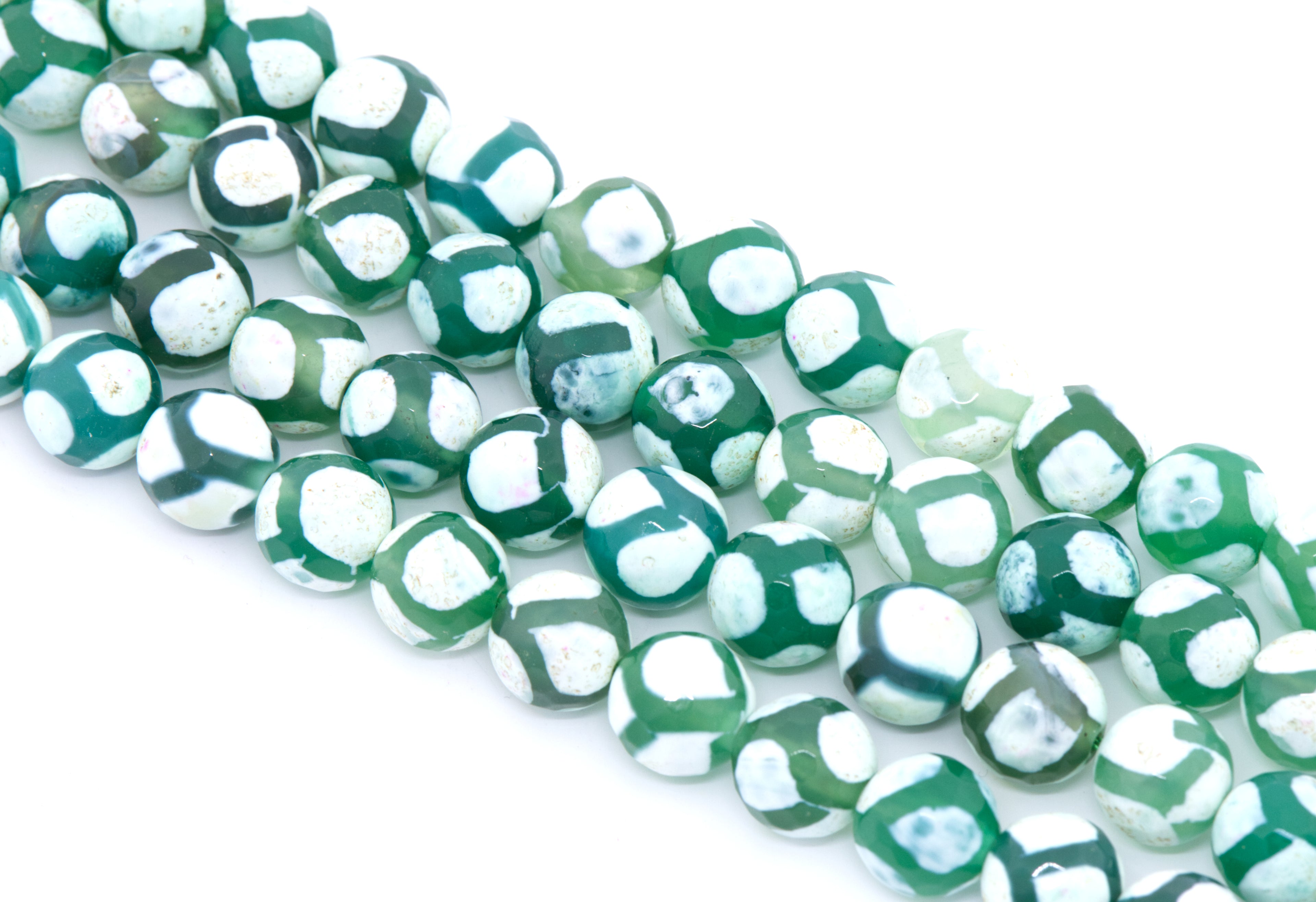 Green and white round Tibetan agate beads arranged diagonally on a clean white background.