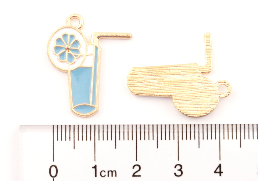 Two blue tropical drink enamel jewelry charms shown on a white background with a ruler at the bottom for scale. 