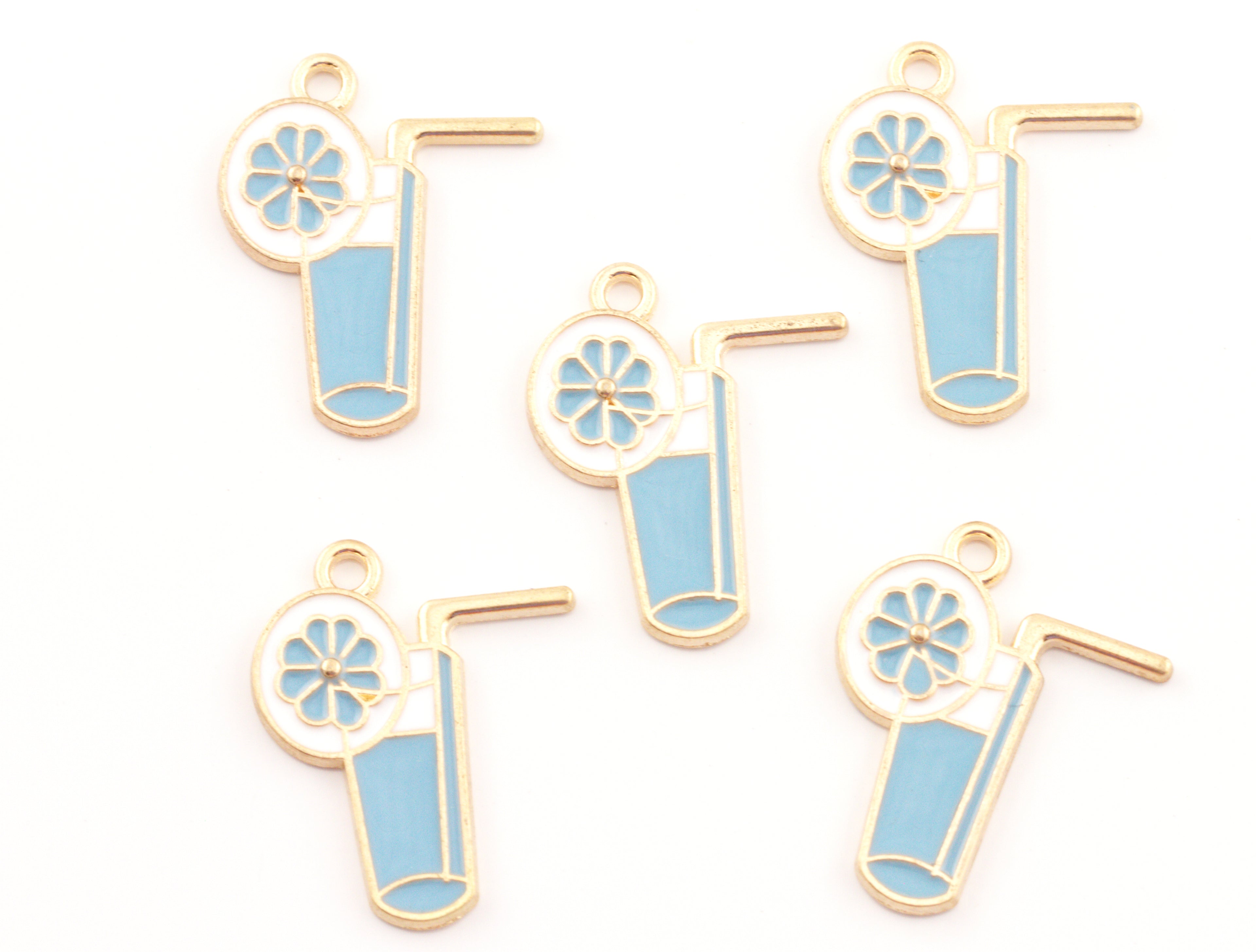 Five enamel blue tropical drink charms with  garnish and a straw, shown on a plain white background.