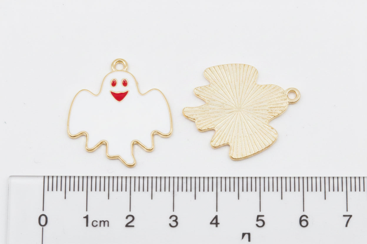 Two white ghost charms on a gray background with a ruler at the bottom for scale. 